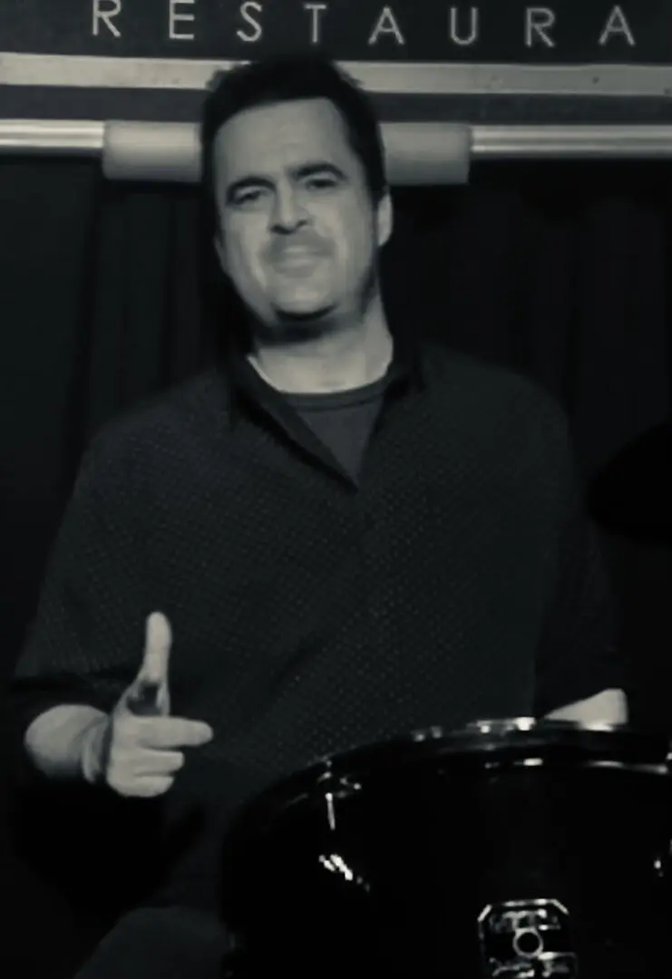 A man holding a drum stick in front of him.