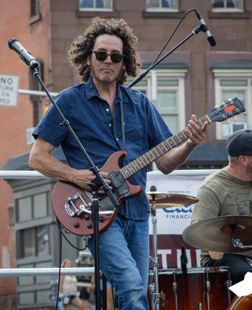 A man playing an electric guitar on stage.