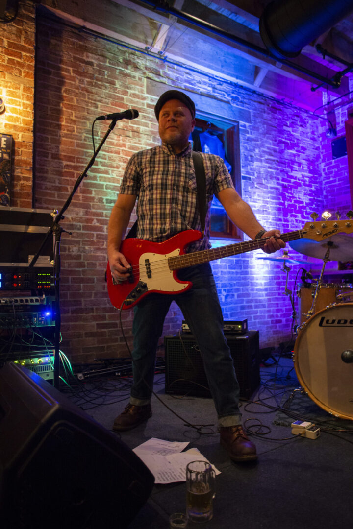 A man playing guitar in front of a band.