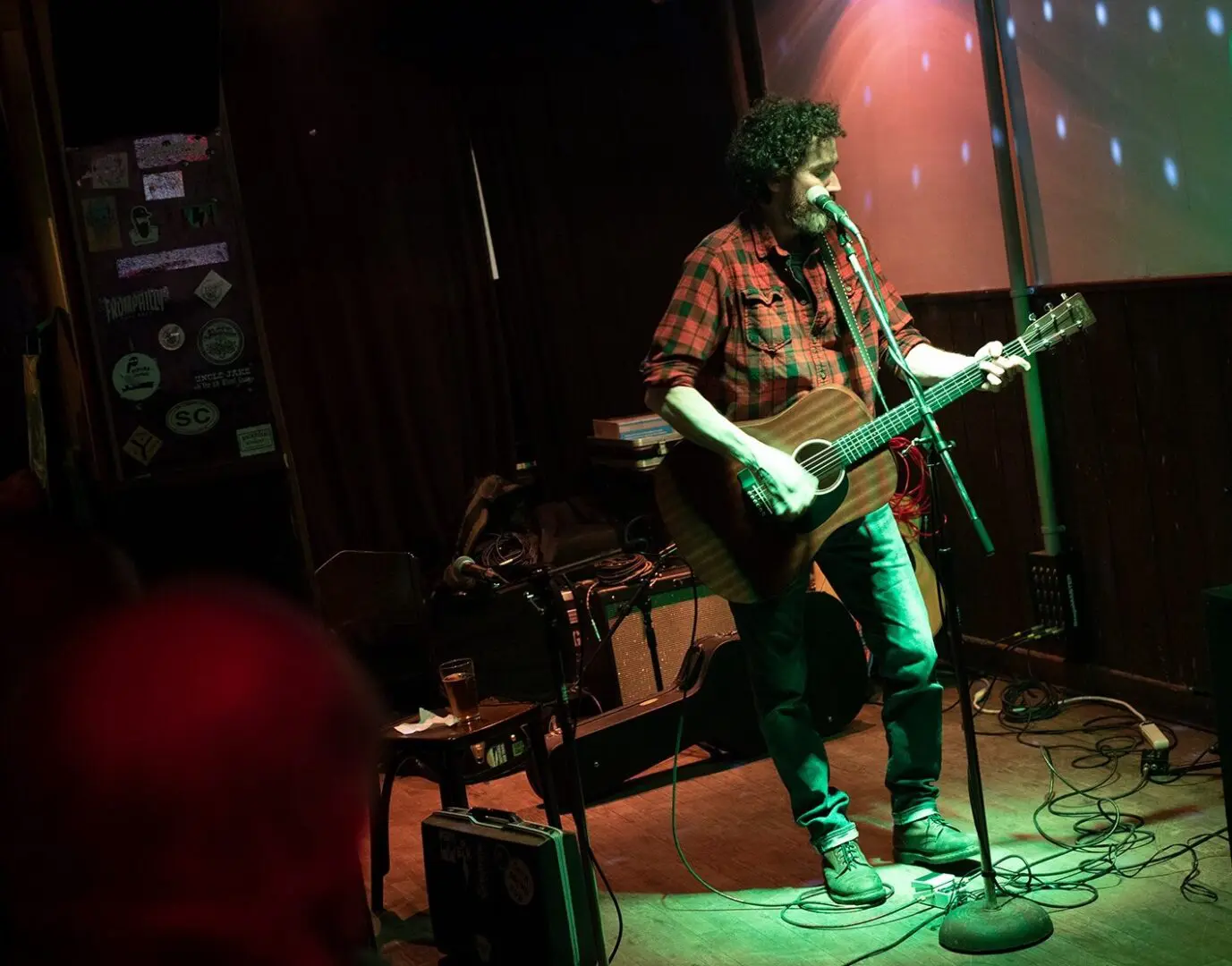 A man with a guitar and microphone on stage.