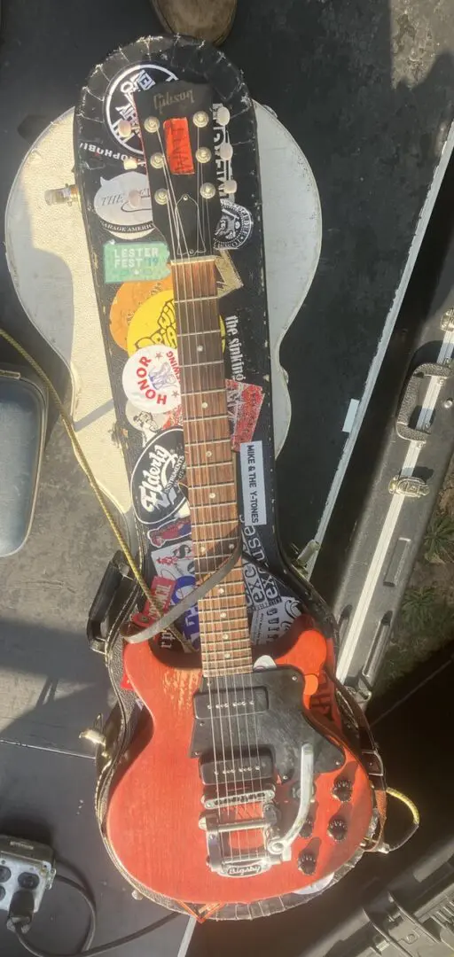 A guitar sitting on top of a case.